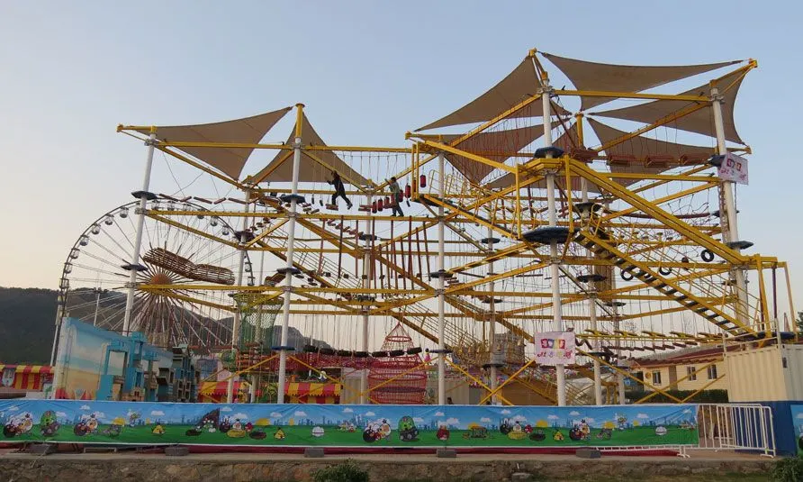 Parque de aventura de varios niveles en estructura metálica al aire libre, con toldos
